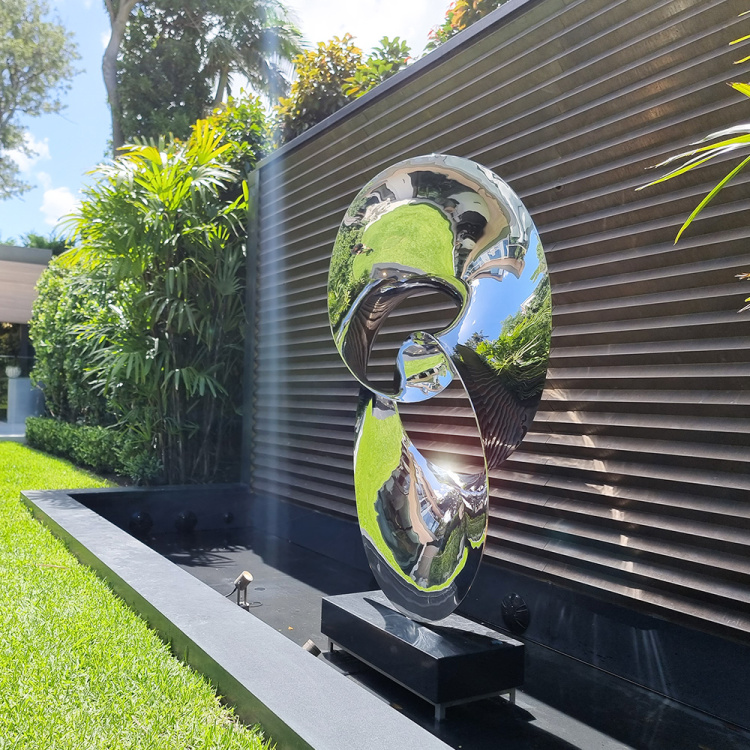 stainless steel water sculpture in garden